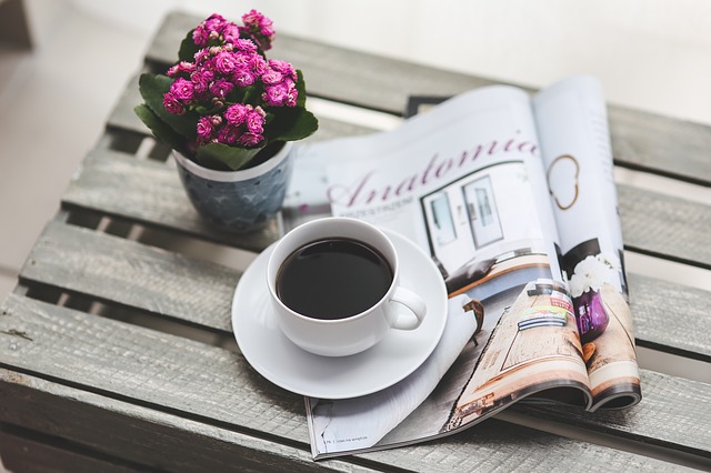 image of a cup of coffee, a magazine and a potted plant